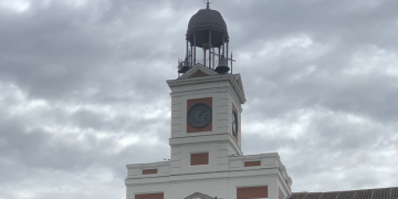Primer plano del reloj de la Puerta del Sol en un día nublado.