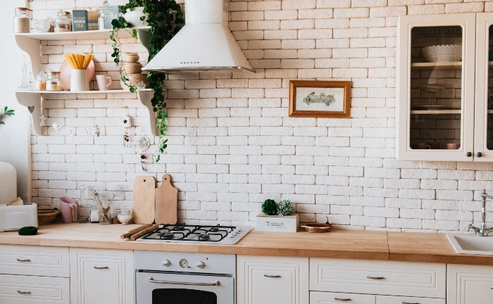 white kitchen with white tile and wood counter top