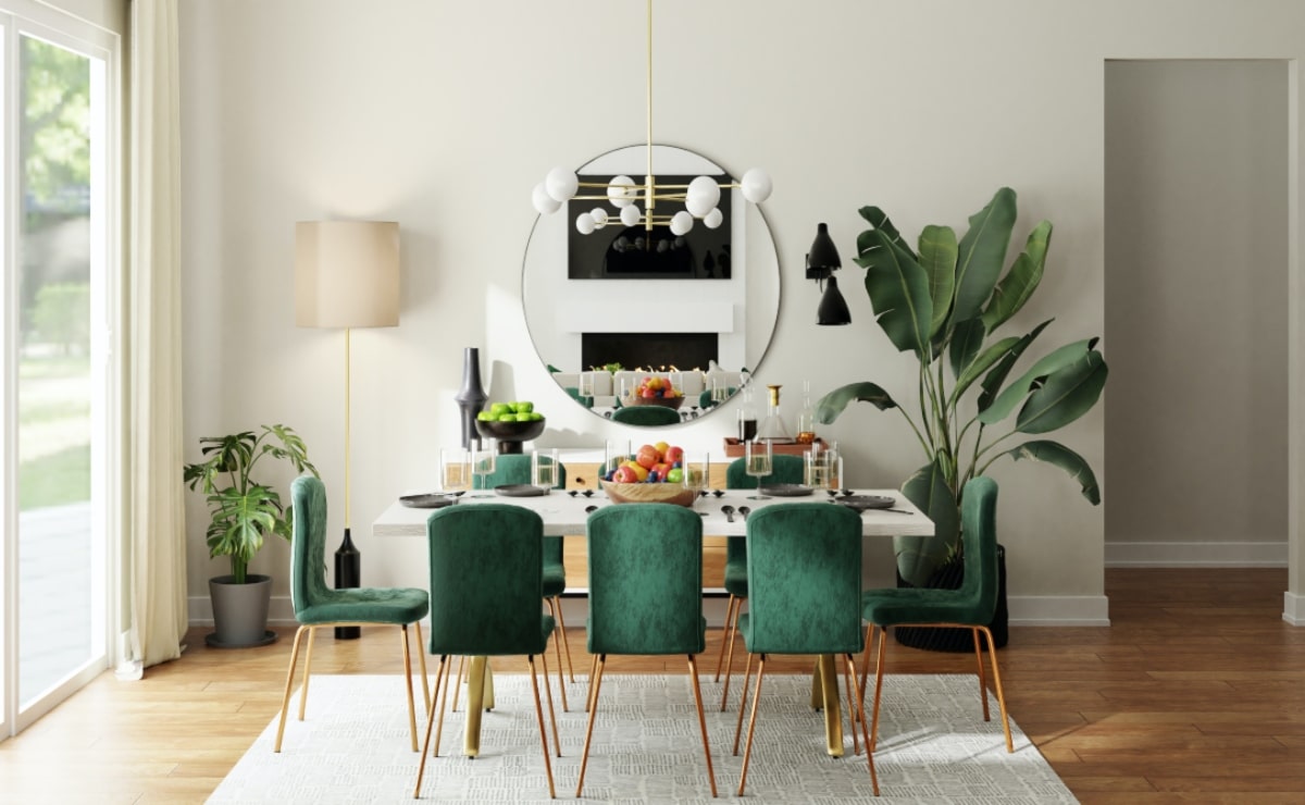 mesa comedor rectangular blanca, con sillas verdes con patas de madera, en un ambiente con espejo, lámpara, alfombra y planta