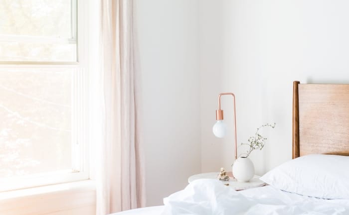 dormitorio en tonos blancos con algún detalle en rosa