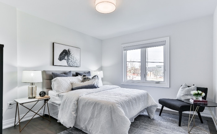 habitación con ventana blanca y ropa de cama y accesorios en tonos grises