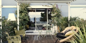 terraza amplia con mobiliario neutro y muchas plantas