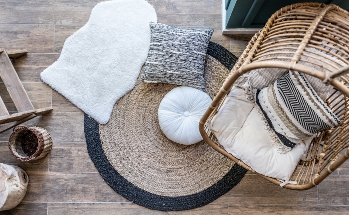 vista desde arriba de habitación con salfombra y sillón colgante de fibras, y cojines en tonos blancos y neutros