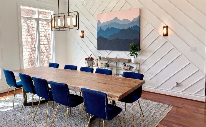 dining room with honeycombed wall, bay window, blue upholstered chairs and rectangular wooden table