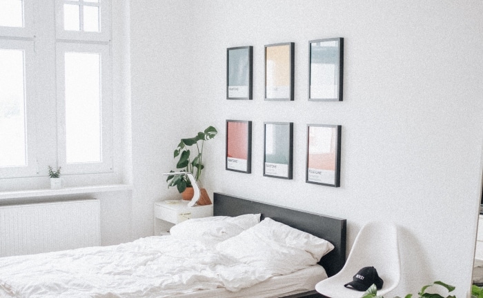 dormitorio colcha blanca con serie de 6 cuadros sobre cabecero