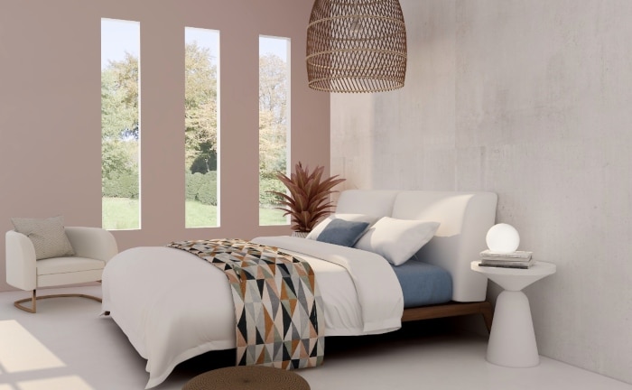 dormitorio con una pared blanca y otra rosada con tres ventanas verticales, tonos crudos en la habitación