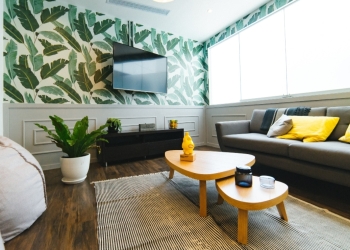 salón en madera y gris, con plantas y papel pintado de hojas verdes