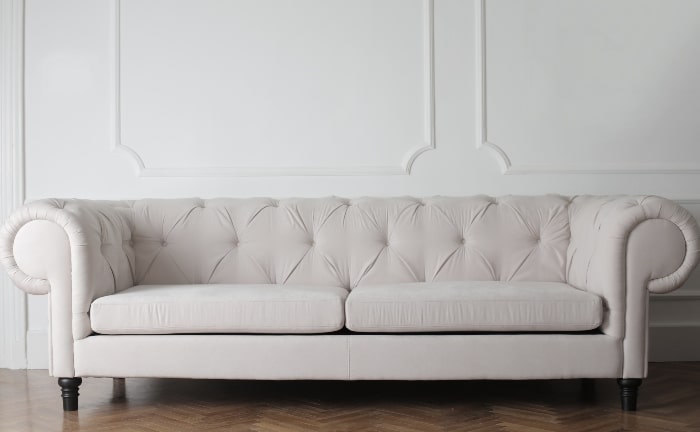 chester sofa in off-white against white wall and wooden floor
