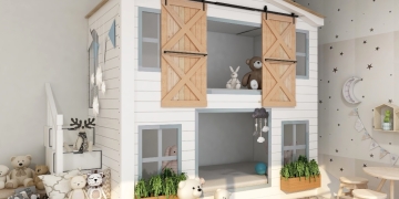 habitación niños con literas en forma de casa de madera blanca y varios juguetes