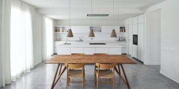 mesa y sillas de madera en cocina blanca minimalista