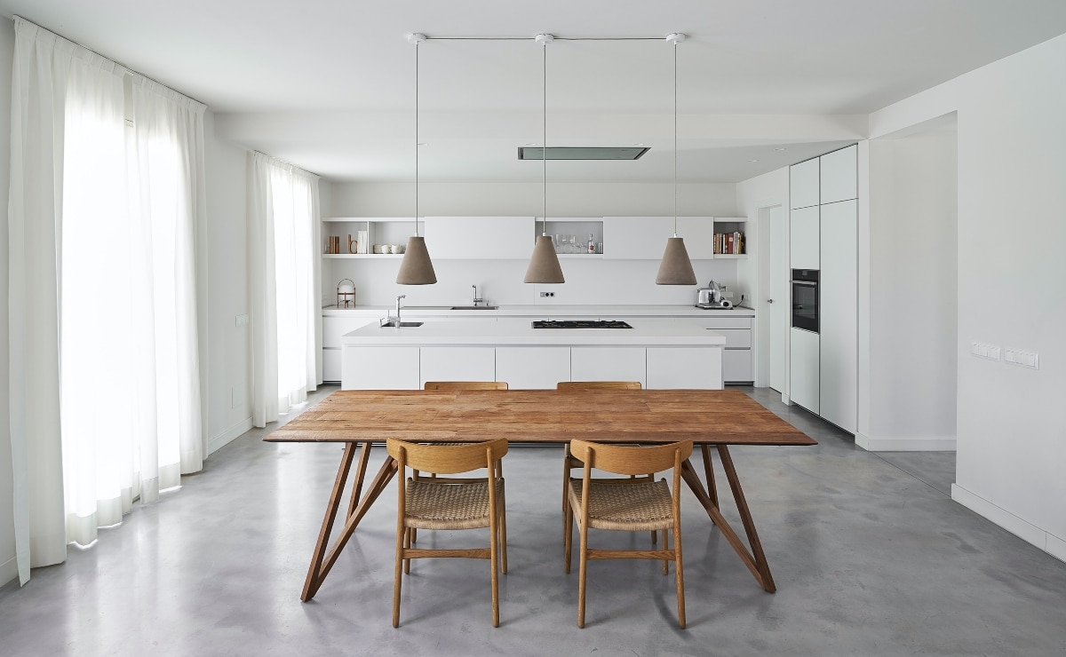 mesa y sillas de madera en cocina blanca minimalista