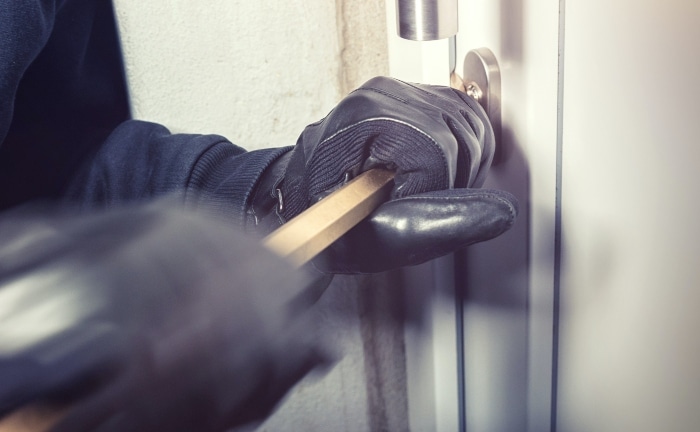 Ladrón intentando abrir una puerta de una casa