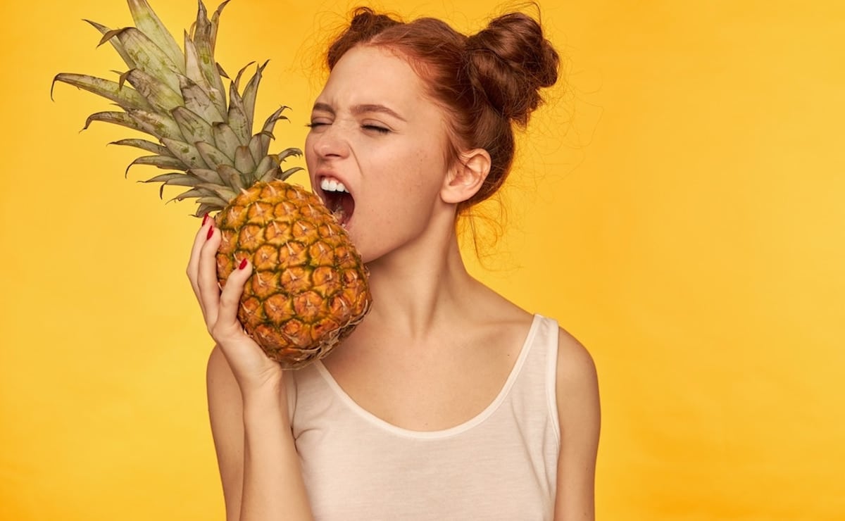 mujer comiendo fruta piña