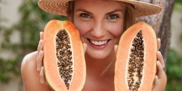 mujer feliz comiendo semillas papaya