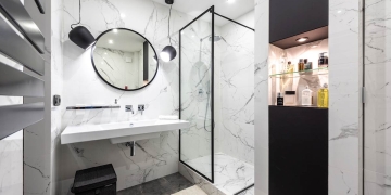 Baño con decoración en marmol y perfilería negra