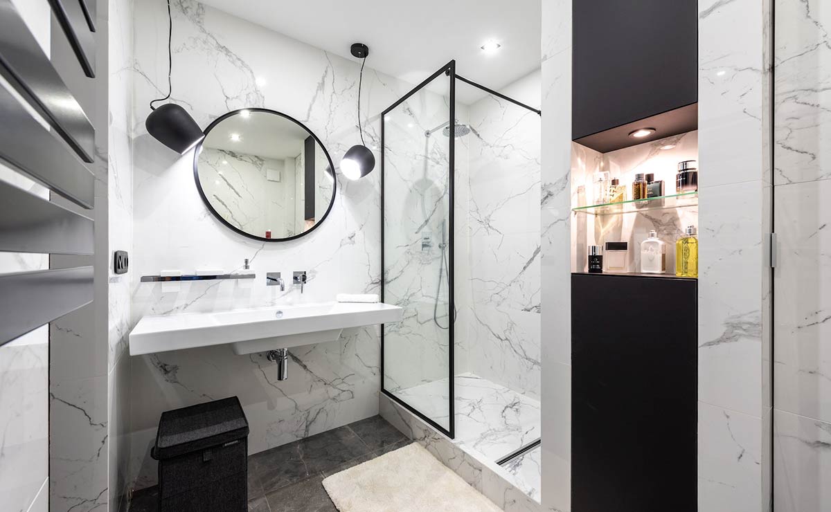 Baño con decoración en marmol y perfilería negra